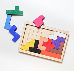 two pieces of wooden puzzle sitting next to each other on top of a white surface