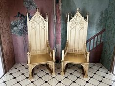 two wooden chairs sitting on top of a tiled floor