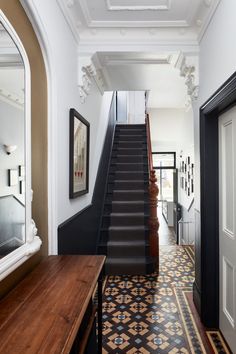 the stairs in this house are painted black and white with geometric designs on them, along with a wooden table