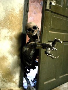 a creepy looking skeleton standing in an open door