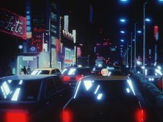 cars driving down a busy city street at night with neon lights on the buildings and signs