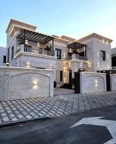 a large white building with lots of windows and lights on it's front entrance