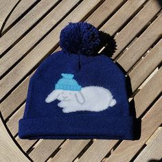 "If you like bunnies and beanies, you are in the right place! It's Beanie Bunny on a Beanie Details: * Material: 100% acrylic * Size: Adult Beanie 8.2\" x 7.9\" (21cm x 20cm) * Colors: Navy blue with white bunny outlines in gray, light blue small beanie * Care: Hand wash with cold water Beanie Bunny is also available as an enamel pin and as part of the Bunnies with Hats sticker sheet! This is my original design, hope you like it as much as I do! It is made in China by my production partner using Playful Blue Winter Beanie, Cute Blue Winter Hat, Playful Hats For Cold Weather, One Size Fits Most, Playful Cold Weather Hat, One Size Fits Most, Blue Novelty Hat, One Size Fits Most, Cute Blue Knitted Hat, Cute Blue Beanie Hat, Playful Blue Knitted Hat, Rabbit Beanie