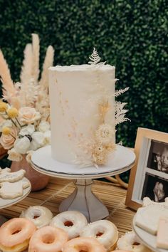 a white cake with frosting and sprinkles sits on a table surrounded by other pastries