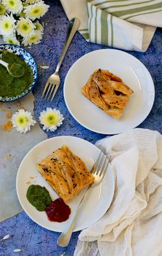 two white plates topped with food next to flowers