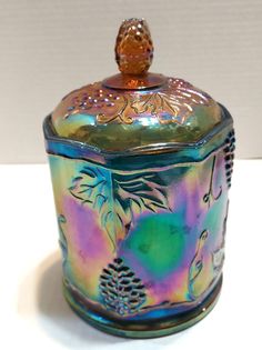 a colorful glass jar sitting on top of a table