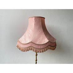 a pink lamp shade hanging from a wall