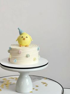 a white cake with a yellow bird on top