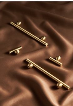 three brass handles on a brown satin surface