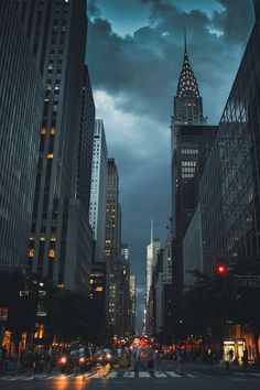 a city street filled with tall buildings under a cloudy sky