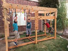 two children playing on a wooden structure in the yard