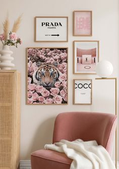 a pink chair sitting in front of a wall with pictures on it and a vase filled with flowers