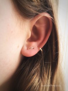 a close up of a person's ear with a small gold nose ring on it