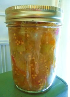 a jar filled with pickles sitting on top of a green table