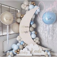 balloon arch with welcome to the world sign and balloons in blue, gold and white colors