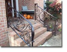 an iron stair rail with pumpkins on the steps