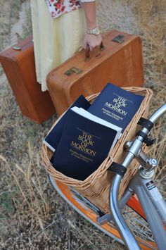 a woman is standing next to her bike with two books in the basket