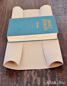 an open book sitting on top of a wooden table next to a roll of paper