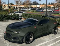 an army green sports car parked in a parking lot