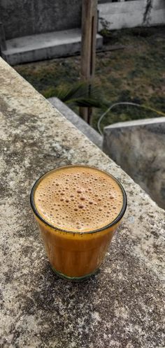 a cup of coffee sitting on top of a stone counter