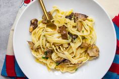 a white plate topped with pasta and mushrooms