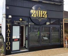 the entrance to a tattoo parlor with large black letters on it's front door