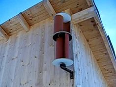 a street light attached to the side of a wooden building on a sunny day with blue skies in the background