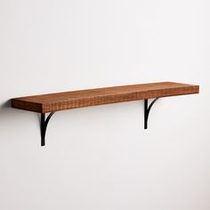 a wooden shelf sitting on top of a white wall