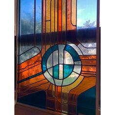 a close up of a stained glass window with blue and orange designs on the side