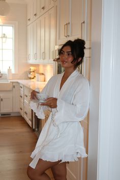 a woman standing in a kitchen holding a magazine