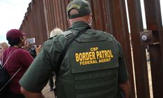 a border patrol is standing in front of a line of people