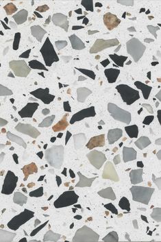 a white and black floor with lots of different colored rocks on top of the floor