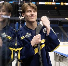 two young men standing next to each other in front of a hockey goalie's net