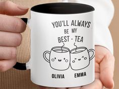 a person holding a coffee mug with two faces on it that says you'll always be my best - tea