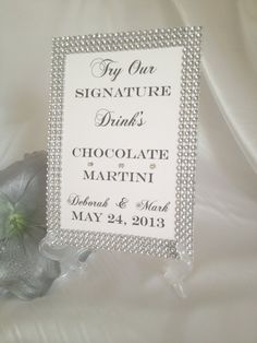 a sign that is sitting on top of a white sheet with flowers in the background