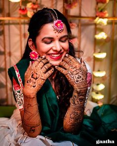 a smiling woman with henna on her hands