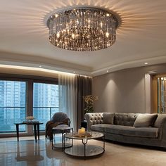 a living room filled with furniture and a chandelier hanging from the ceiling above