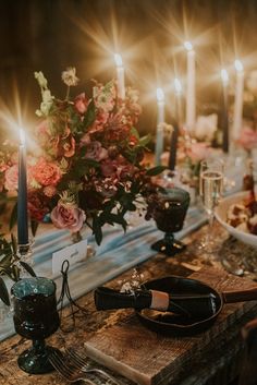 the table is set with candles, plates and utensils for an elegant dinner