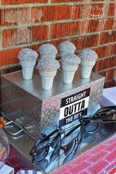 there are some ice cream cones on top of the box and glasses in front of them