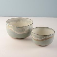 two white bowls sitting next to each other on a table