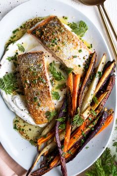 some fish and carrots on a white plate