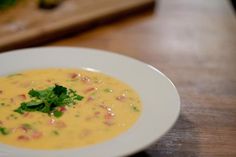 a white bowl filled with soup on top of a wooden table