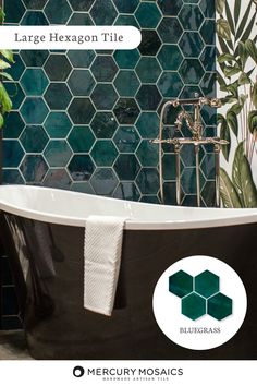 a bath tub sitting next to a tiled wall with green leaves on it and the words, large hexagon tile