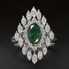 Why we love it:This emerald and diamond cocktail ring is both excellent in quality and breathtaking in design! Beautifully crafted from all top quality materials, the ring has a large and eye catching look that is sure to turn heads!Highlights:- 1.50ct marquise cut emerald- Great quality emerald with rich green color!- 1.60ct of marquise cut diamonds and 0.50ct of round cut diamonds- All bright white and completely eye clean- The rounds are particularly exceptional with all ideal cuts and top gr Big Stone Rings, Cocktail Ring Designs, Sapphire Eternity Ring, Gold Finger Rings, Ladies Rings, Gemstone Diamond Ring, Diamond Pendants Designs, Emerald Cut Diamond Ring, Green Emerald Ring