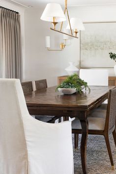 the dining room table is surrounded by white chairs