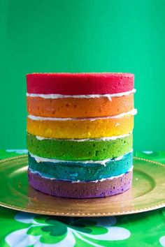 a multi colored cake sitting on top of a gold plate