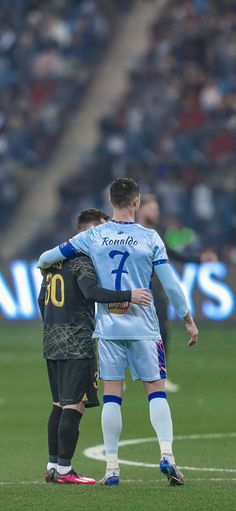 two soccer players are embracing each other on the field