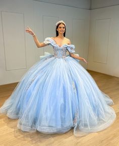 Turn your quinceanera into a magical celebration with this stunning Sky Blue Off-the-Shoulder Quinceañera Dress. This dress features a regal ball gown silhouette and flows gracefully into a dramatic chapel train, making every step feel like a fairy tale moment. The delicate off-the-shoulder neckline highlights your shoulders with elegance, while the sleeveless design ensures comfort throughout your special day. It is made from soft tulle fabric and is adorned with intricate appliques and shimmer Baby Blue Quinceanera Dresses, Dresses With Bows, Baby Blue Quinceanera, Quince Dresses Blue, Gown Silhouette, Poofy Dress, Debut Ideas, Quinceñera Dresses, Quinceanera Dresses Blue