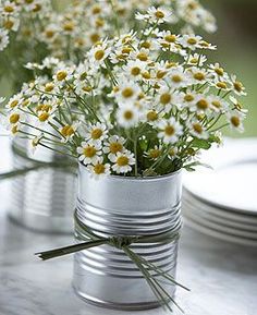 some daisies are in a tin can on a table