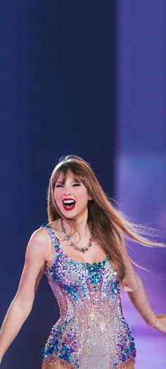 a woman with long hair wearing a colorful dress and holding her hands out to the side